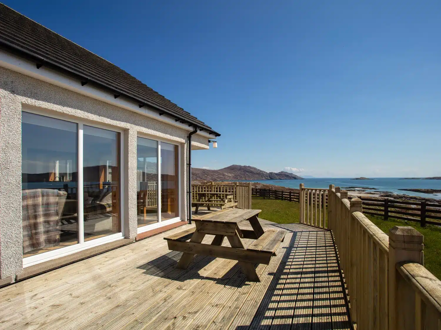 Beachcombers self-catering South Uist - modern house with large windows and decking overlooking the sea