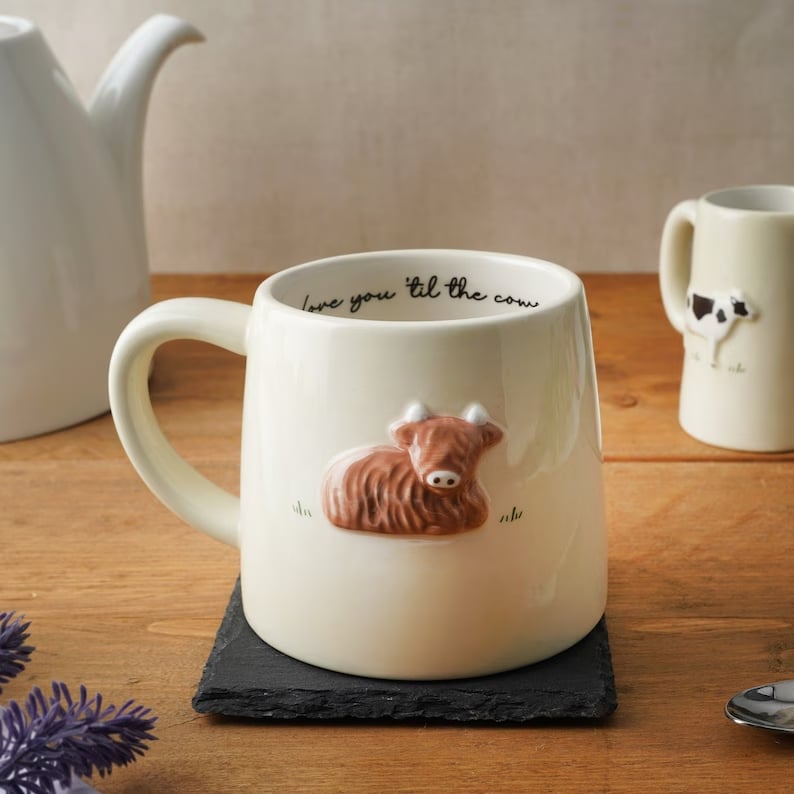 cream ceramic mug with 2D highland cow on side