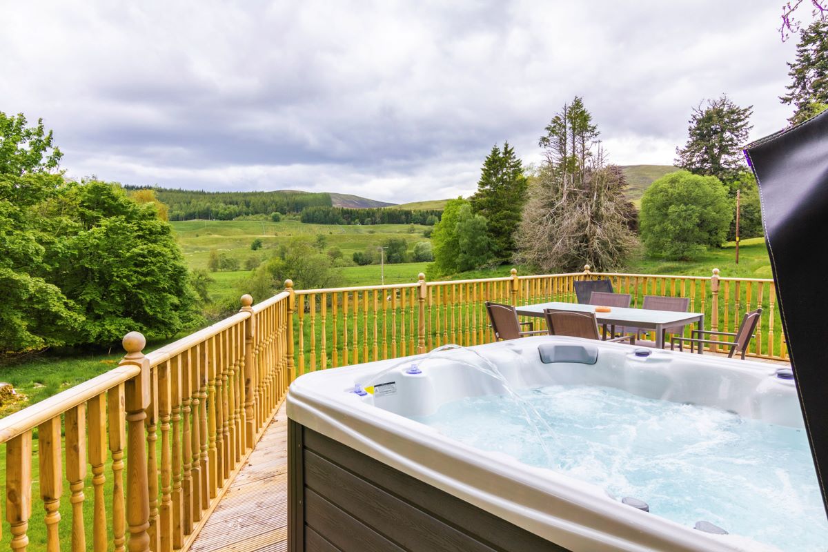 hot tub on decking overlooking trees and fields