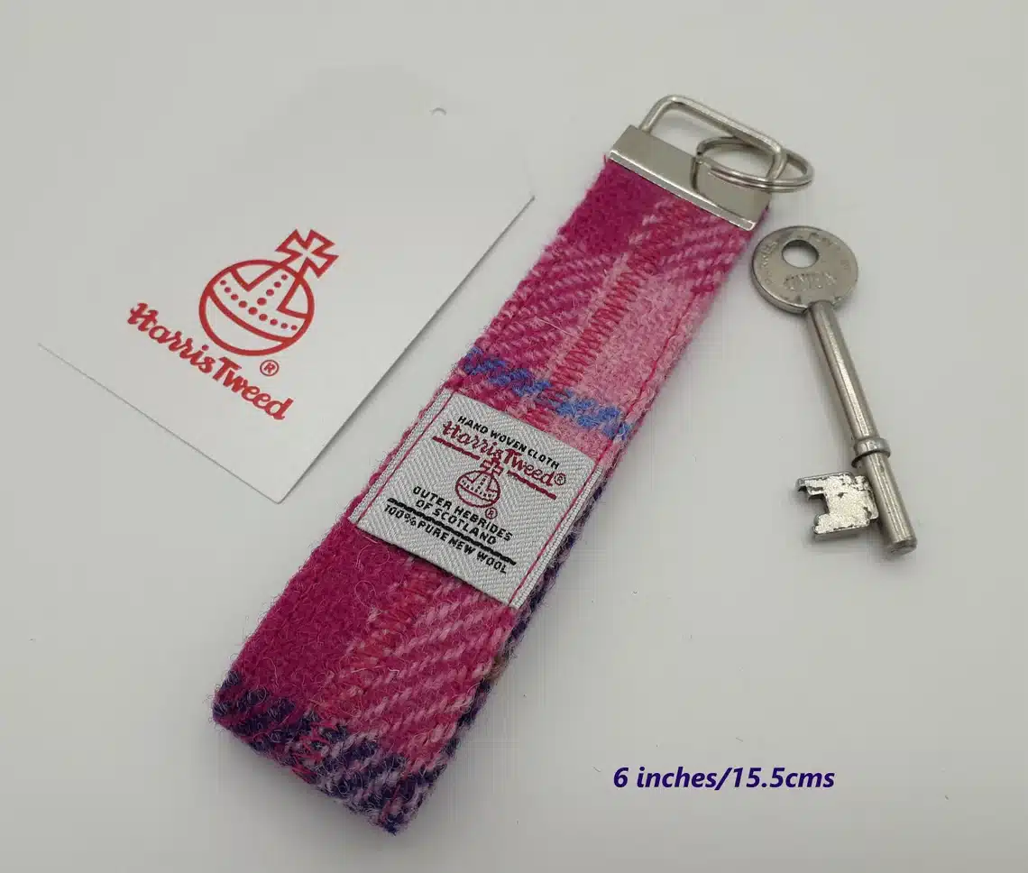 red Harris tweed rectangular key ring with key on white background