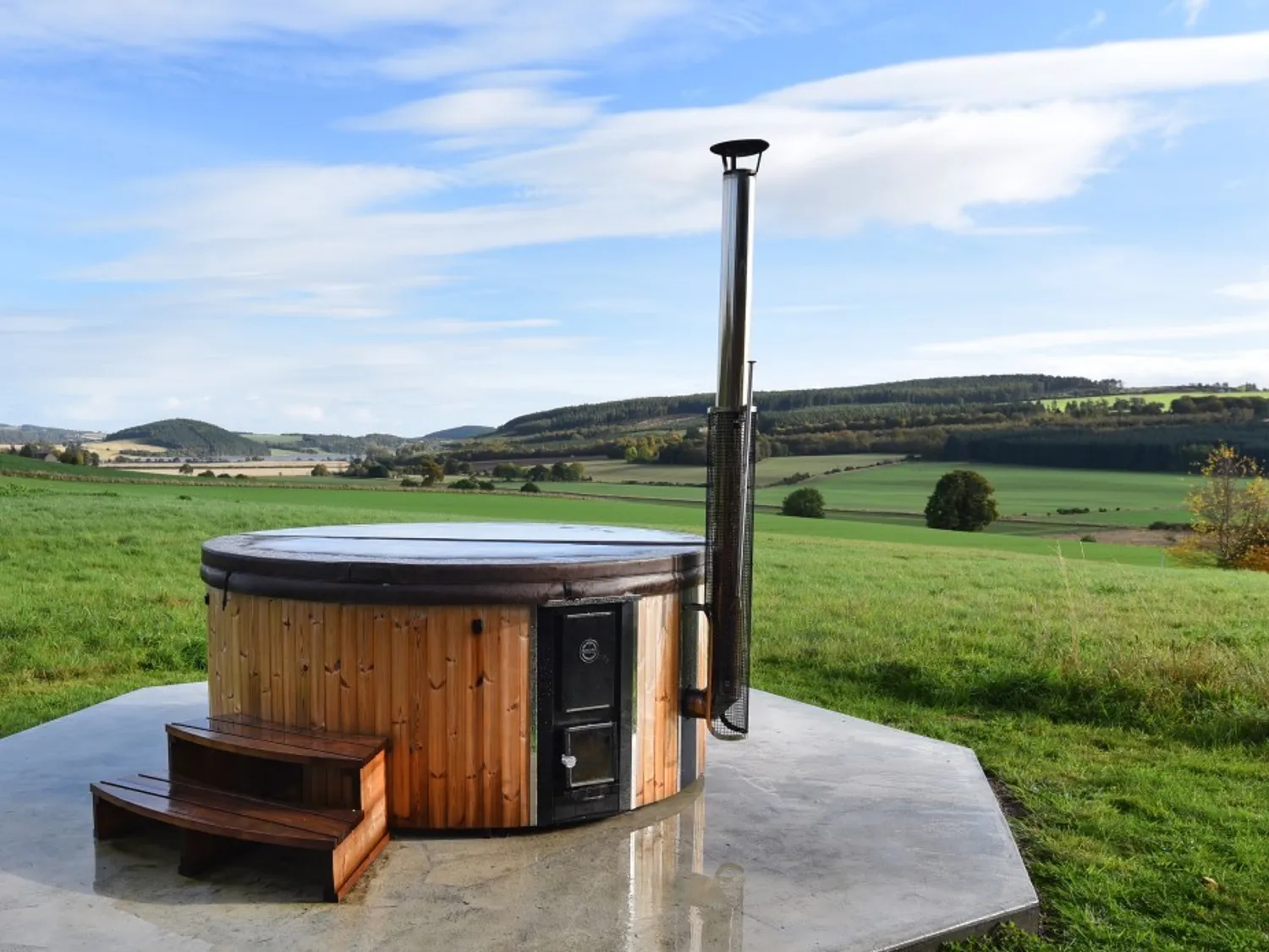 wooden hot tub with views over fields to woodlands
