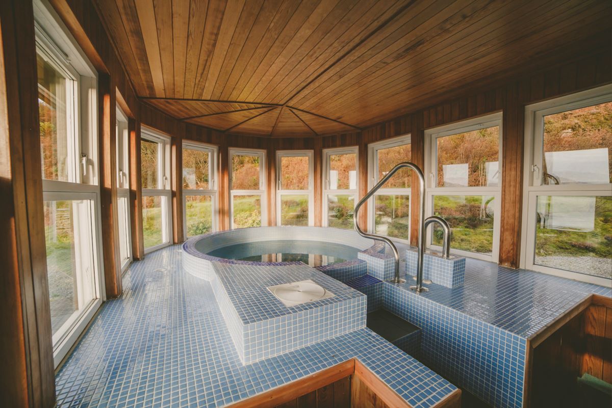 Spa room with hot tub and lots of windows with sea views Seal Bay Cottage