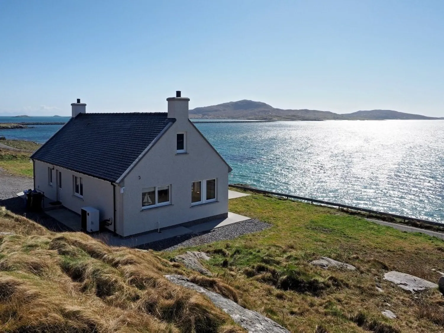 Modern cottage next to the sea with an island in the distance - Sea Spray Cottage South Uist