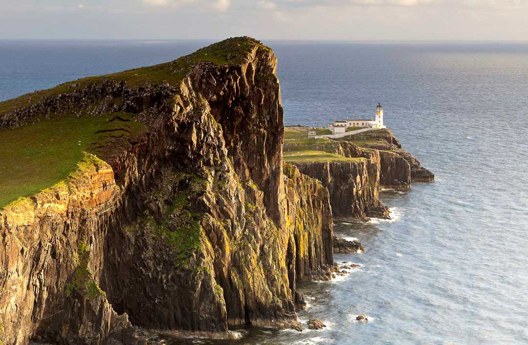 high cliffs with lighthouse on end of point